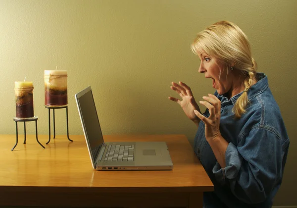 Έκπληκτος ξανθιά γυναίκα χρησιμοποιώντας φορητό υπολογιστή — Φωτογραφία Αρχείου