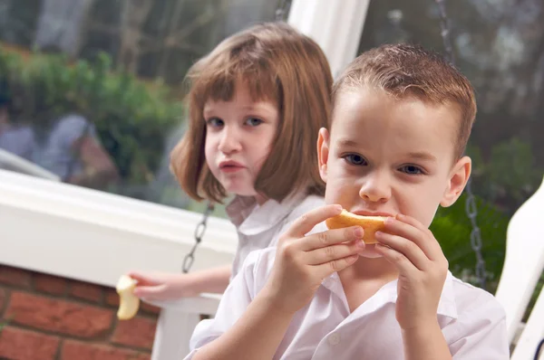 Unga syster och bror äta ett äpple — Stockfoto