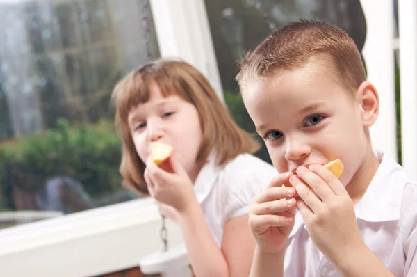Sestra a bratr bavit jíst jablko — Stockfoto