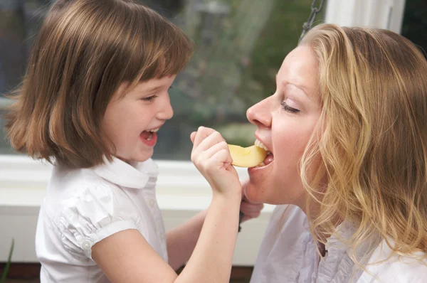 Daughter Having Fun Feeding Mom an Apple Slice — Stock Photo, Image