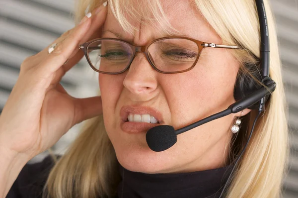 Žena s telefonního sluchátka a bolest hlavy — Stock fotografie