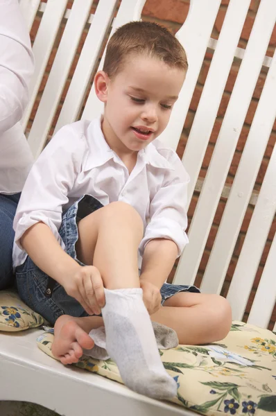 Schattige jongen krijgen gekleed zijn sokken zetten — Stockfoto
