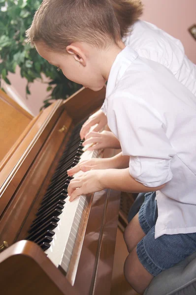 Hermano y hermana tocando el piano juntos — Foto de Stock