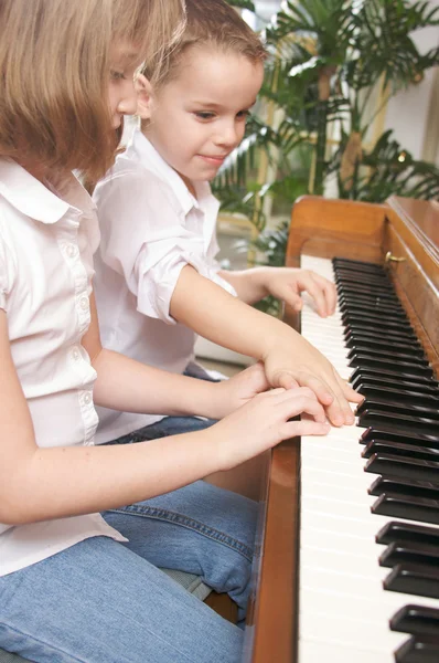 Bruder und Schwester spielen zusammen Klavier — Stockfoto