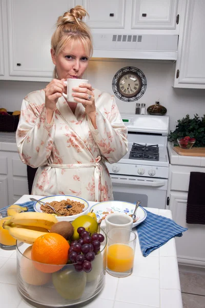 Ελκυστική γυναίκα στην κουζίνα με φρούτα, καφέ, — Φωτογραφία Αρχείου
