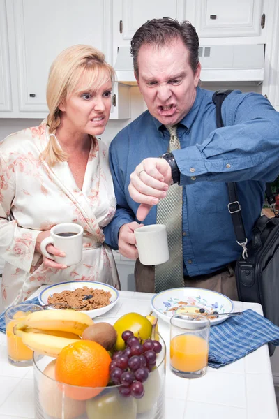 Casal estressado verificando o tempo na cozinha — Fotografia de Stock