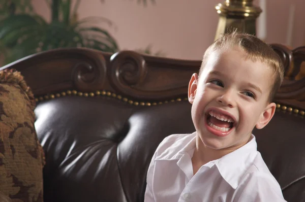 Cute młody chłopak o niebieskich oczach, śmiejąc się — Zdjęcie stockowe