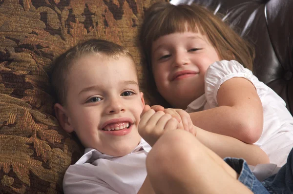 Bratr a sestra baví na gauči — Stock fotografie