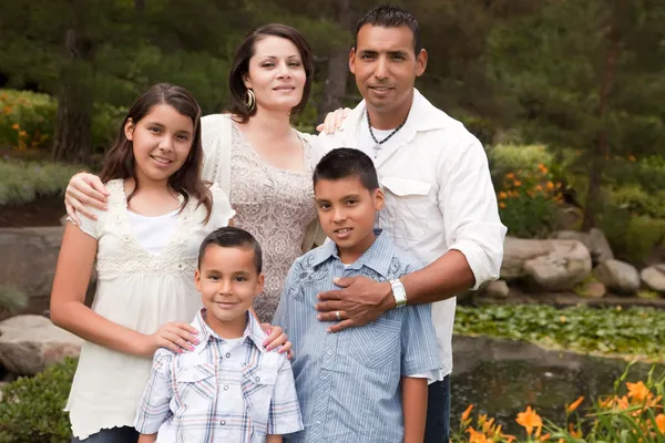 Família hispânica feliz no parque — Fotografia de Stock