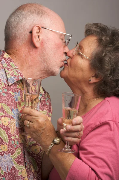 Beijando casal sênior com champanhe — Fotografia de Stock