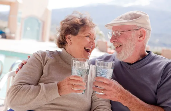 Счастливая пожилая пара, наслаждающаяся напитками — стоковое фото