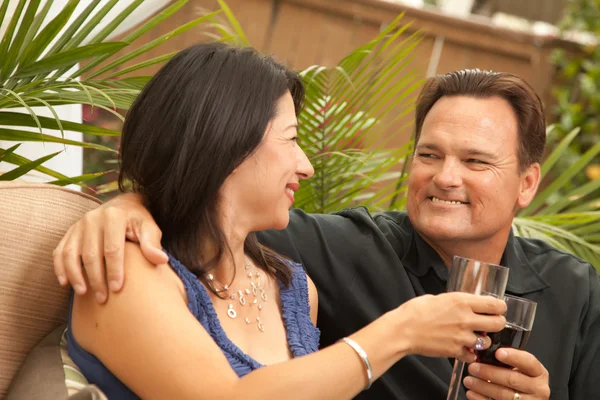Lächelndes hispanisches und kaukasisches Paar beim Weintrinken — Stockfoto