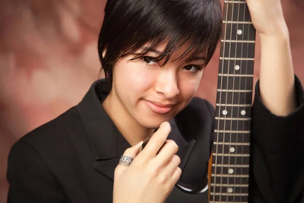 Mnohonárodnostní dívka představuje se svou kytarou — Stock fotografie
