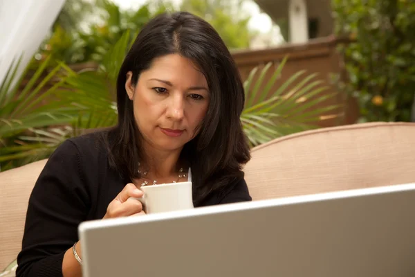 Mulher hispânica com café e laptop — Fotografia de Stock