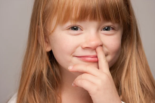 红头发女孩用手指在她的鼻子 — 图库照片