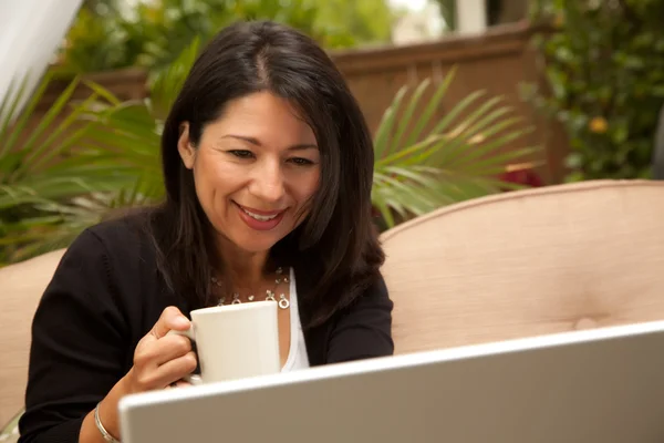 Латиноамериканка с кофе и ноутбуком — стоковое фото