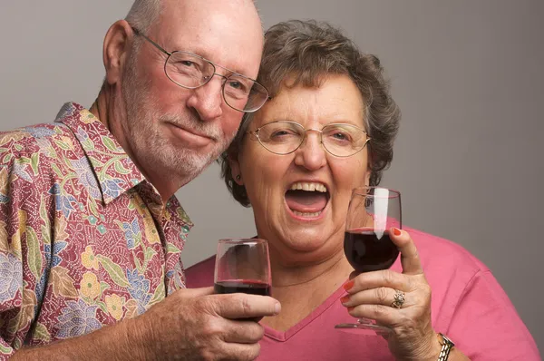 Feliz pareja de ancianos tostando vino — Foto de Stock