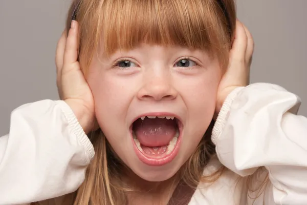 Chica pelirroja con las manos sobre las orejas — Foto de Stock