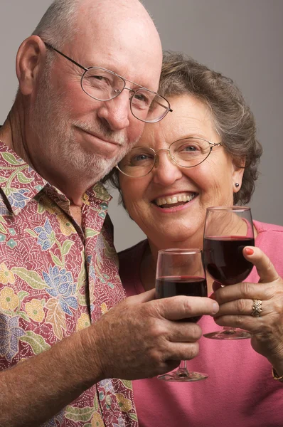 Glückliches Seniorenpaar stößt auf Wein an — Stockfoto