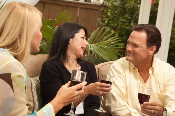 享受葡萄酒在露台上的三个朋友 — 图库照片