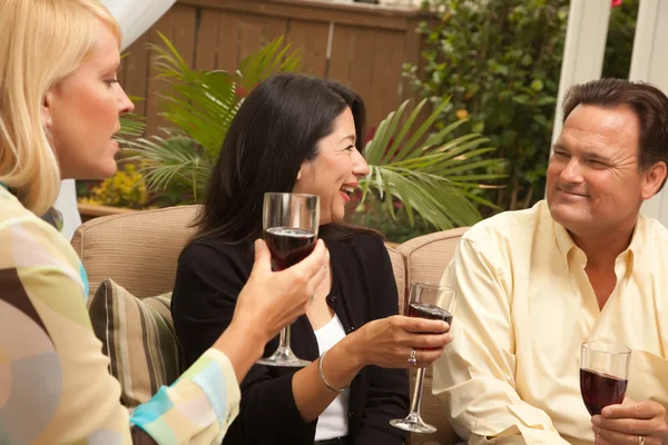 Três amigos desfrutando de vinho no pátio — Fotografia de Stock