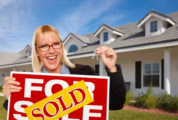 Happy Woman Holding Keys and Sign Stock Picture