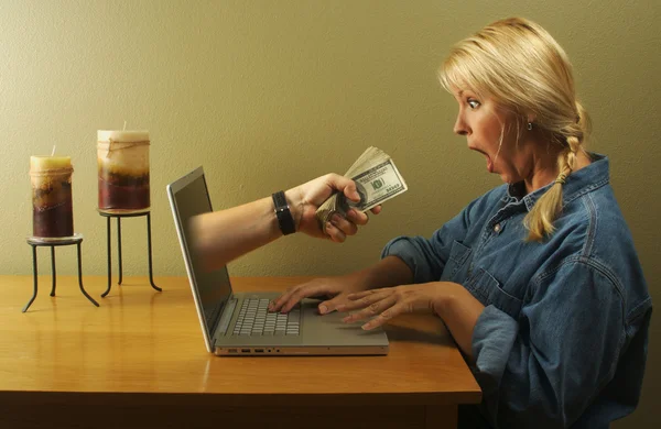 Geld via laptop scherm en vrouw — Stockfoto