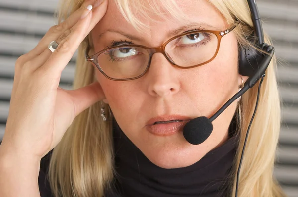 Woman with Phone Headset and Headache Stock Image
