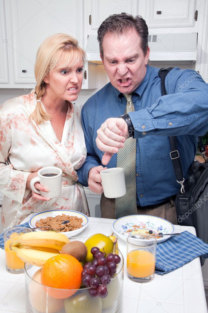 Stressed Couple Checking Time in Kitchen