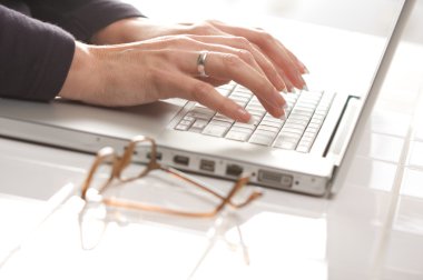 Close Up of Female Hands Using Laptop Computer clipart