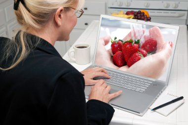 ekranda meyve ile dizüstü bilgisayar kullanan kız
