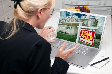 heyecanlı kadın mutfakta bir ev satın almak veya satmak için laptop kullanma
