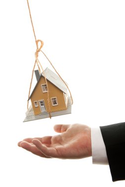 Mans Hand Under Dangling House clipart