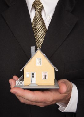 Businessman Holding Holding House clipart