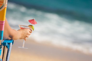 Woman Relaxing on Beach with Drink clipart