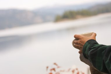 Woman Enjoys Morning Cup Coffee on the Lake. clipart