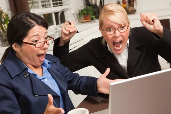 Dos mujeres usando el ordenador portátil celebran el éxito —  Fotos de Stock