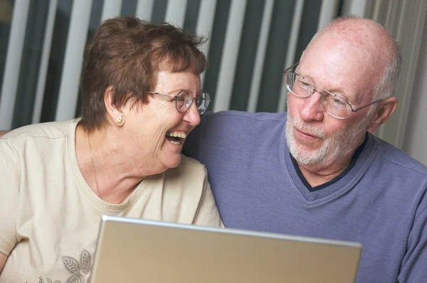 Adultos mayores trabajando en una computadora portátil —  Fotos de Stock