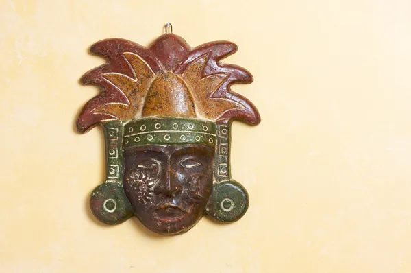 Eine kunstvolle Myan-Maske hängt an einer hellgelben Wand — Stockfoto