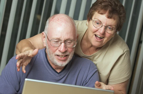 Adultos mayores trabajando en una computadora portátil — Foto de Stock