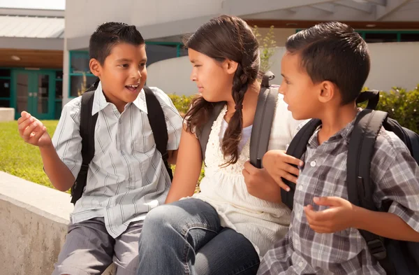 Crianças hispânicas na escola com mochilas — Fotografia de Stock