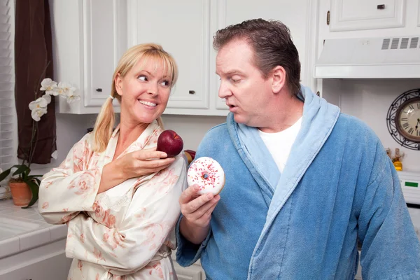 Пара на кухне с фруктами и пончиками — стоковое фото