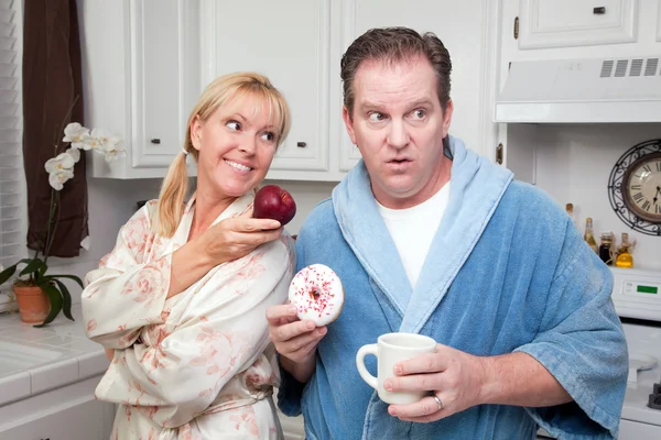 Par i köket med frukt och munkar — Stockfoto