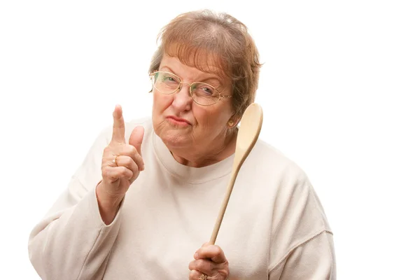 Расстроенная пожилая женщина с деревянной ложкой — стоковое фото