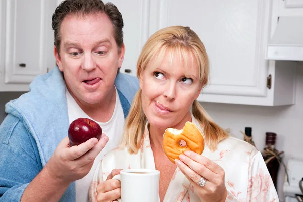 Paar in der Küche mit Obst und Donuts — Stockfoto