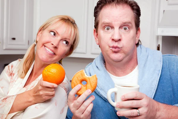 Paar in keuken met fruit en donuts — Stockfoto