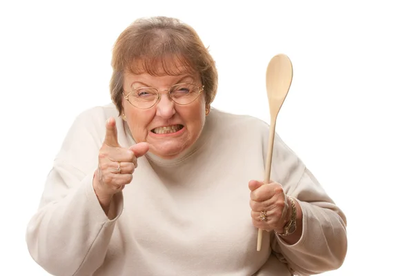 Mujer mayor trastornada con la cuchara de madera aislada —  Fotos de Stock