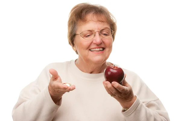 Šťastný starší žena drží jablko a prášky — Stock fotografie