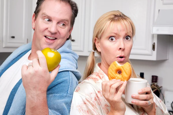 Пара на кухне с фруктами и пончиками — стоковое фото