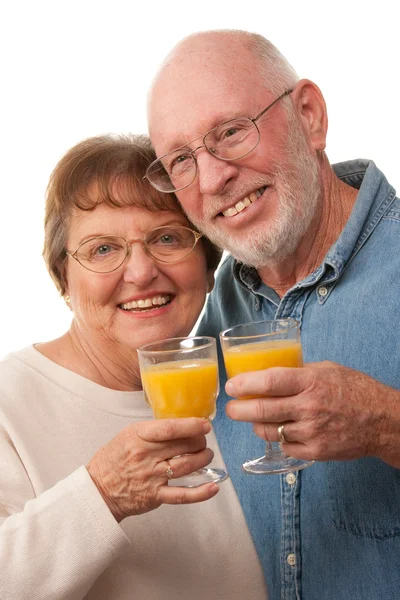 Casal sénior feliz com suco de laranja — Fotografia de Stock